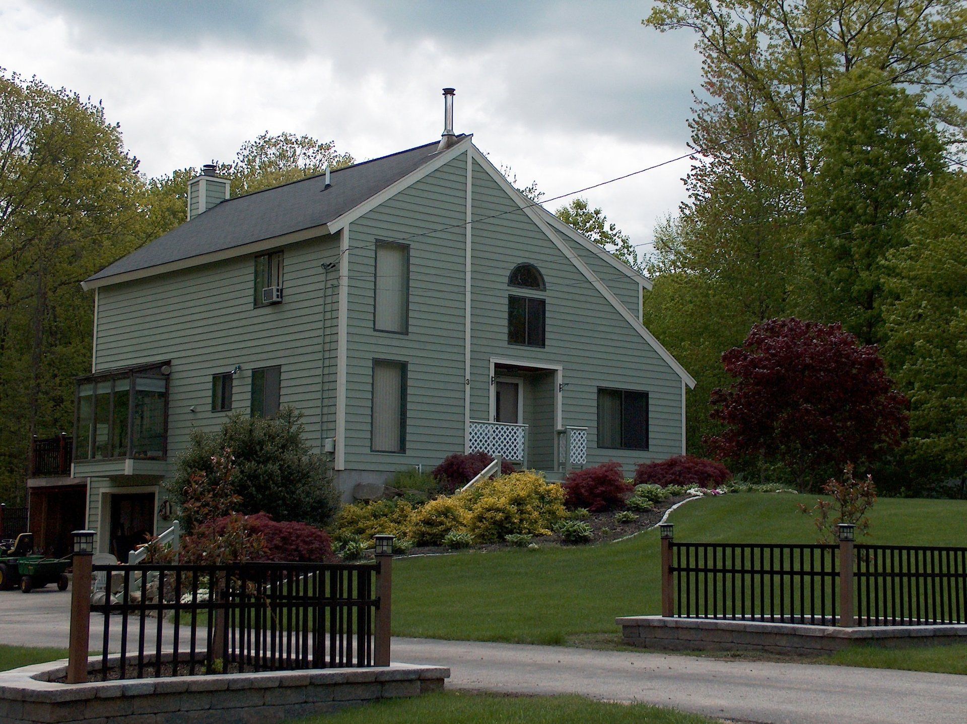A green house with a black fence in front of it