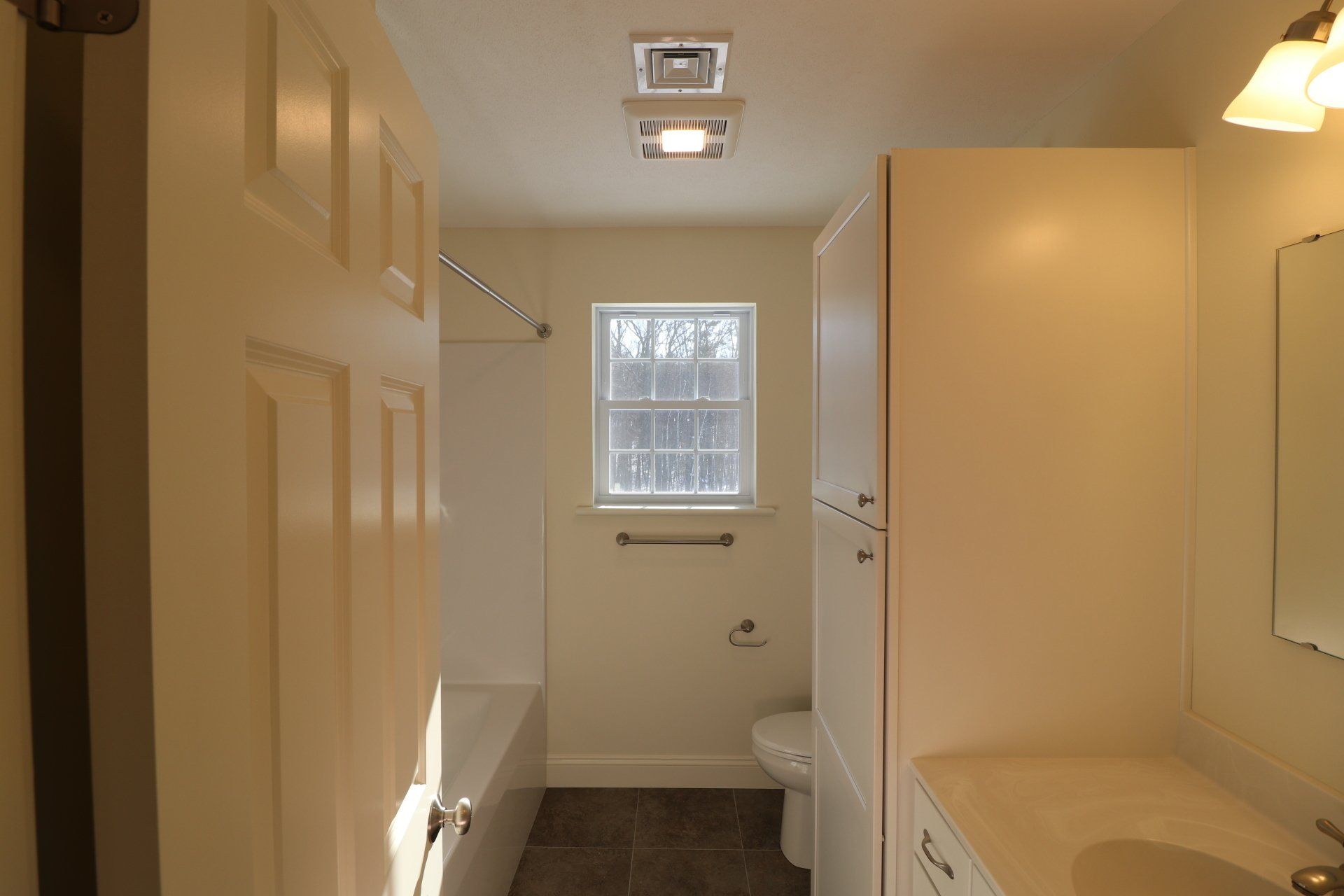 A bathroom with a sink a toilet and a window