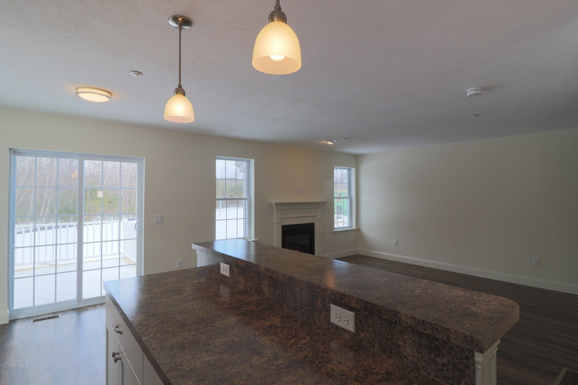 An empty kitchen with a fireplace and sliding glass doors