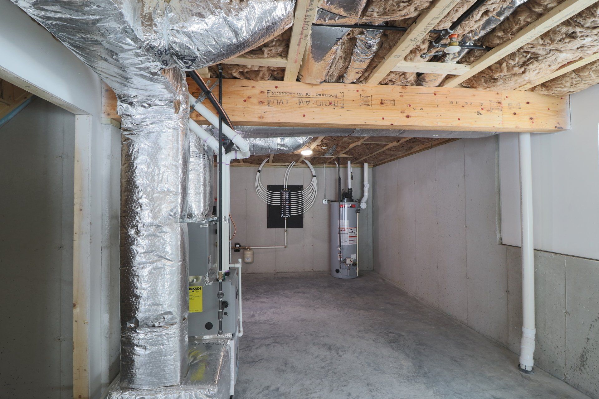A basement with a lot of pipes coming out of the ceiling.