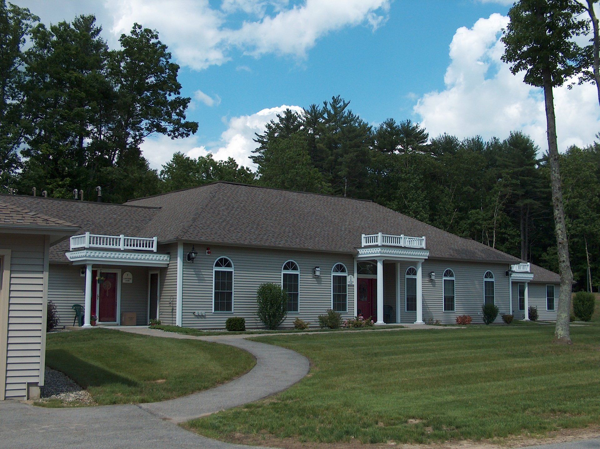 A large house with a gray roof and a red door