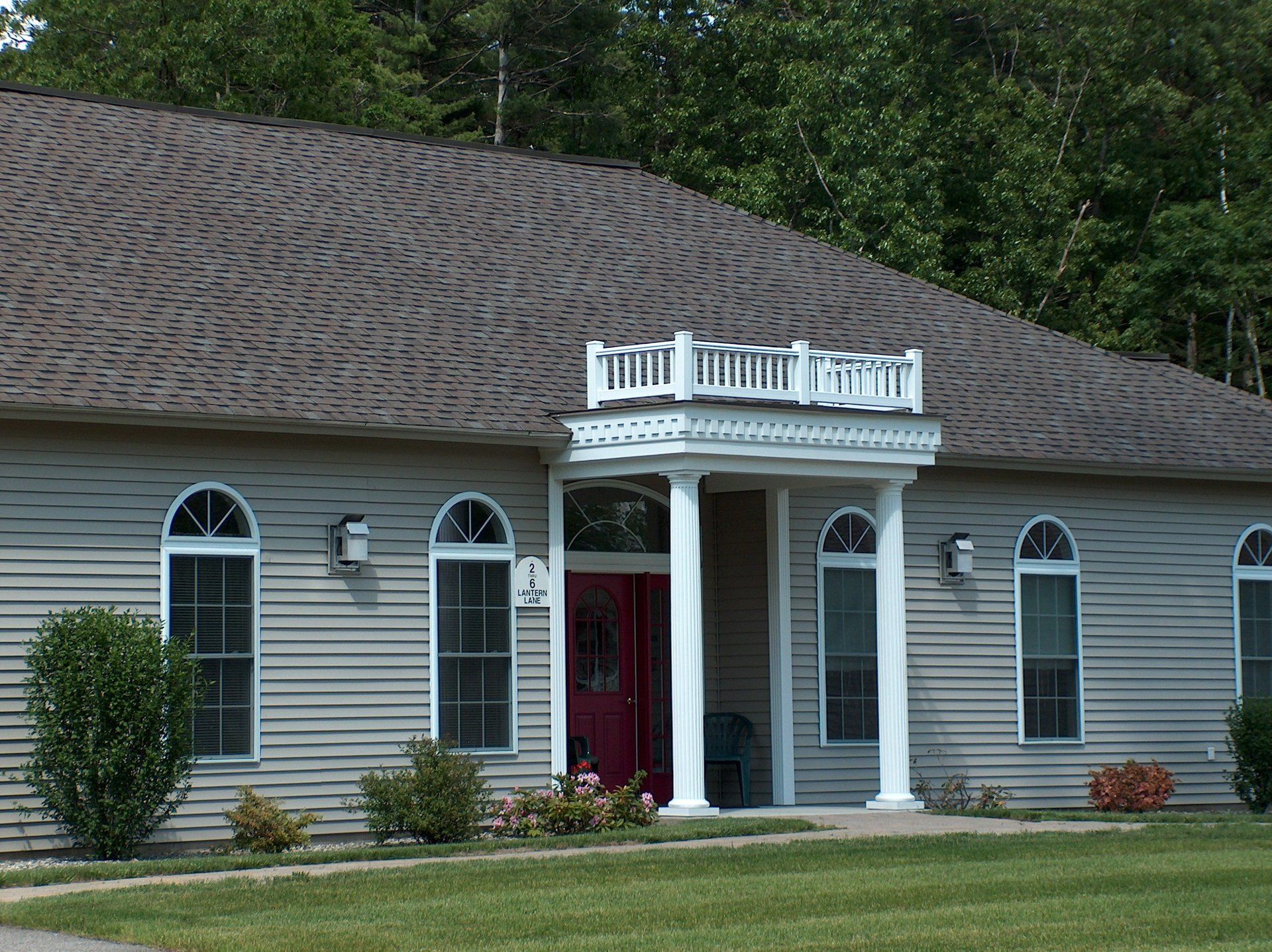 A house with a porch and a red door