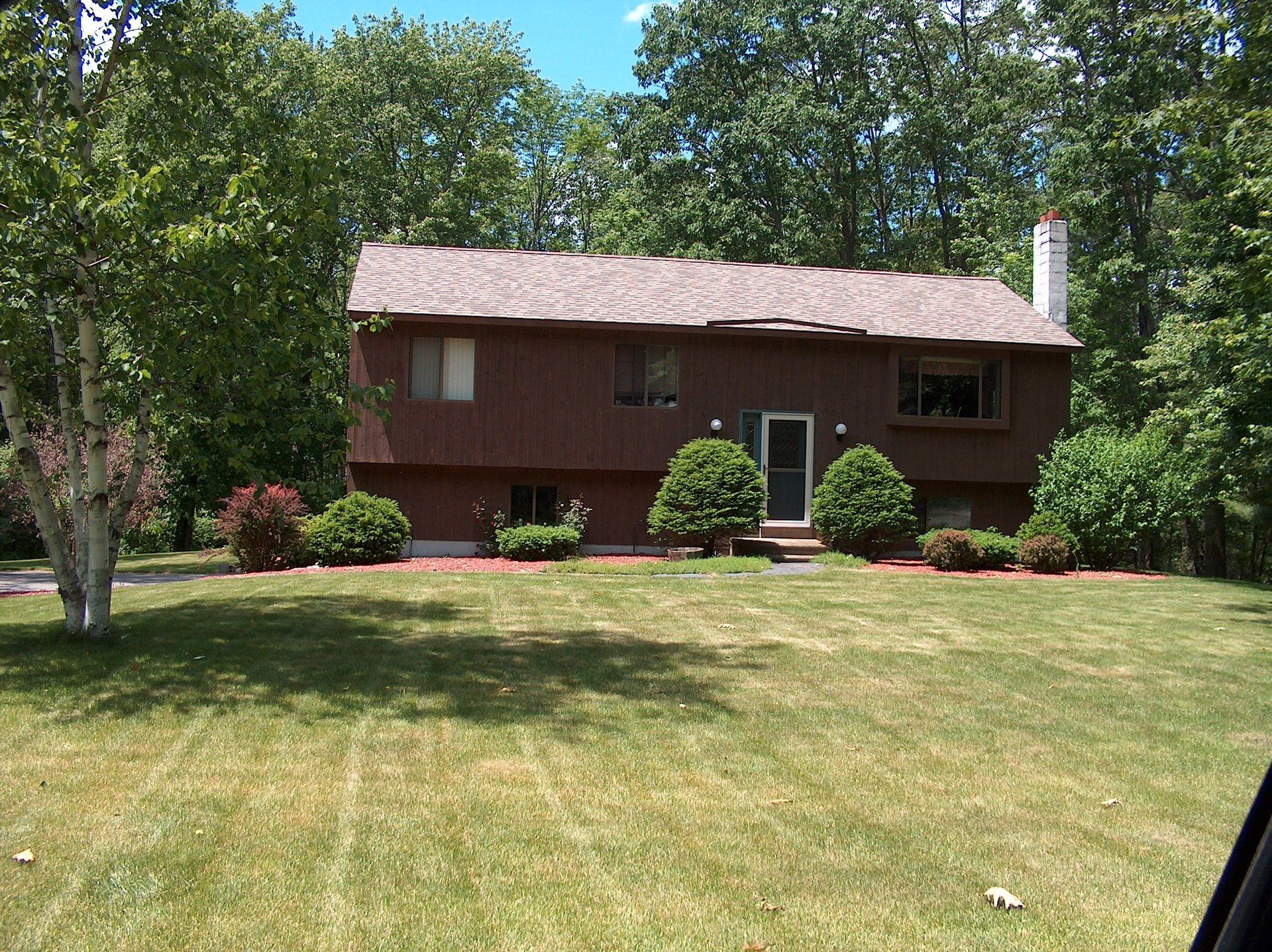 A house with a large lawn in front of it