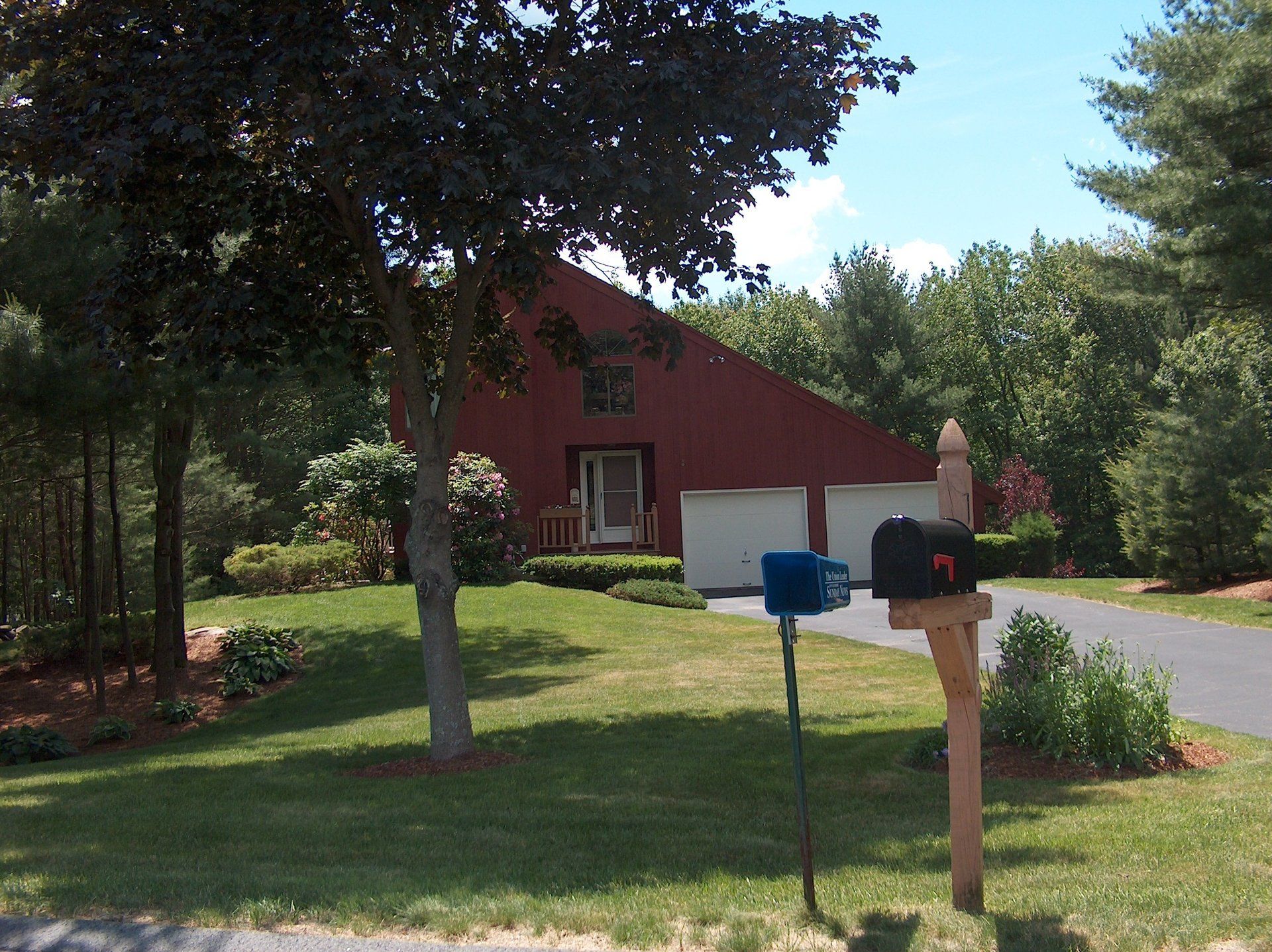 A mailbox in front of a house with the letter t on it