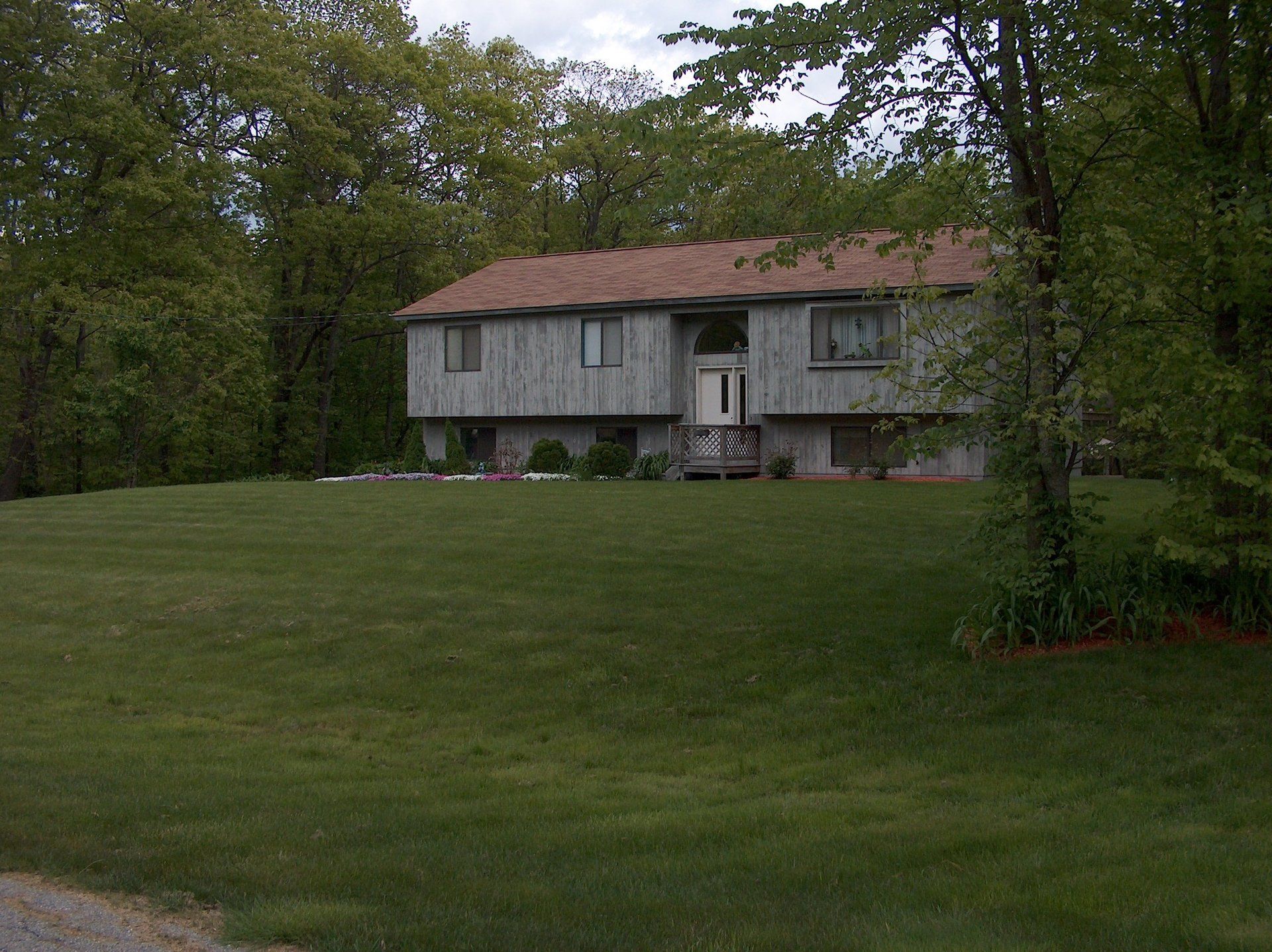 A house with a lush green lawn in front of it
