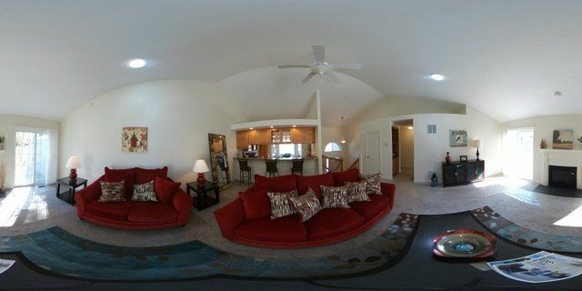 A living room with two red couches and a ceiling fan