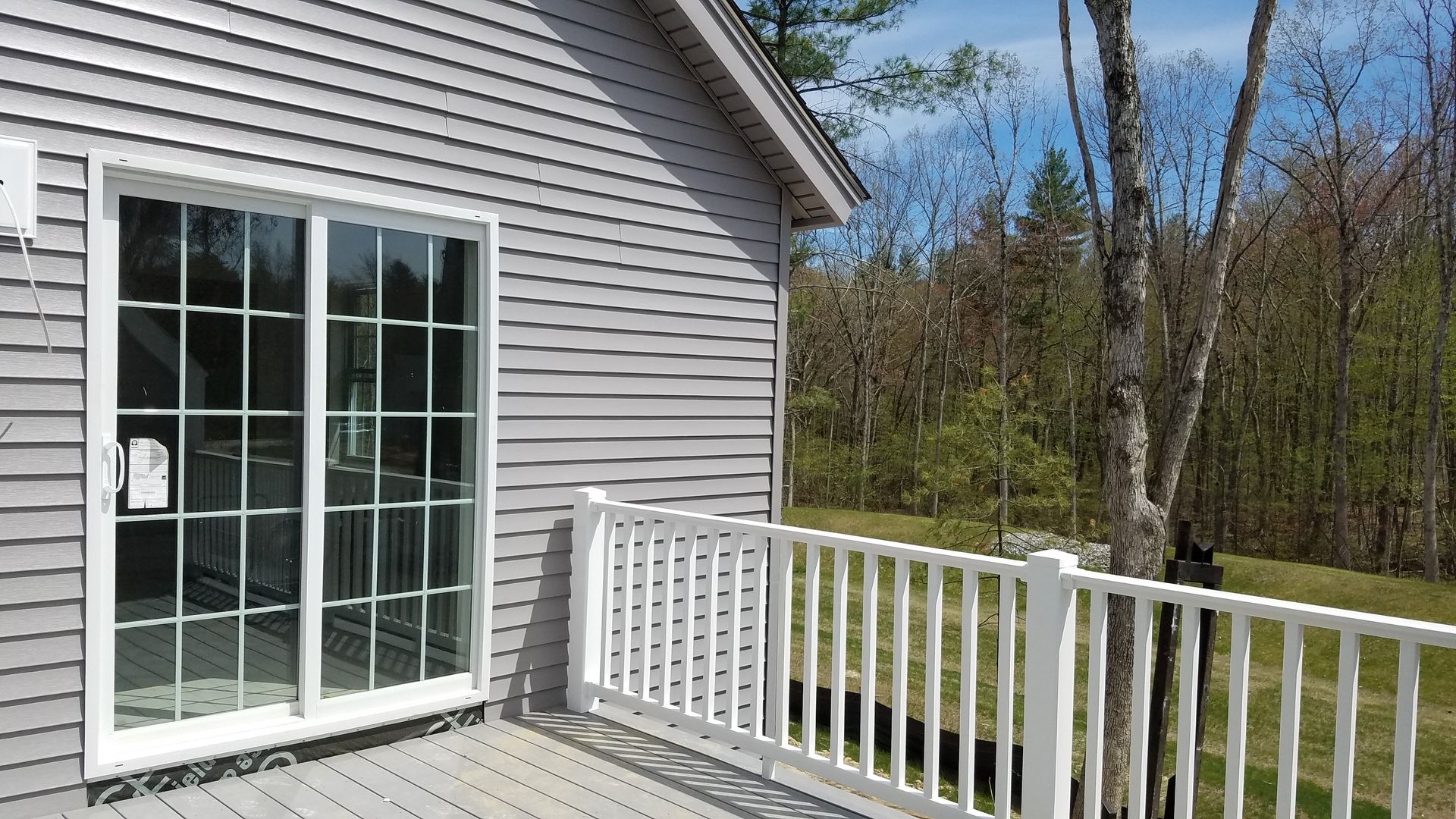 A house with a sliding glass door and a white railing