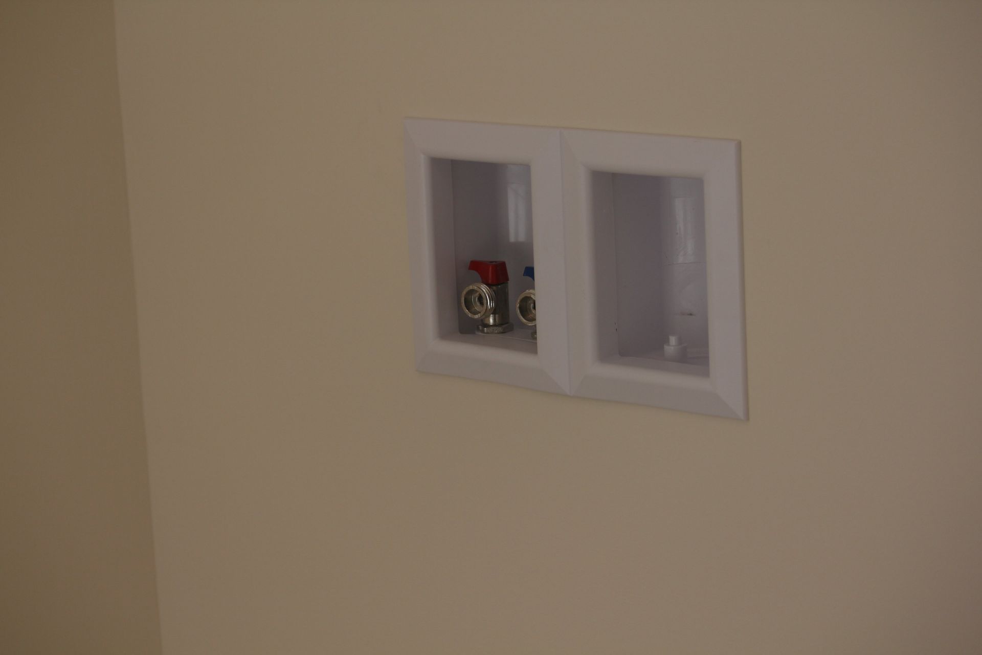 A washer and dryer outlet is built into a wall.