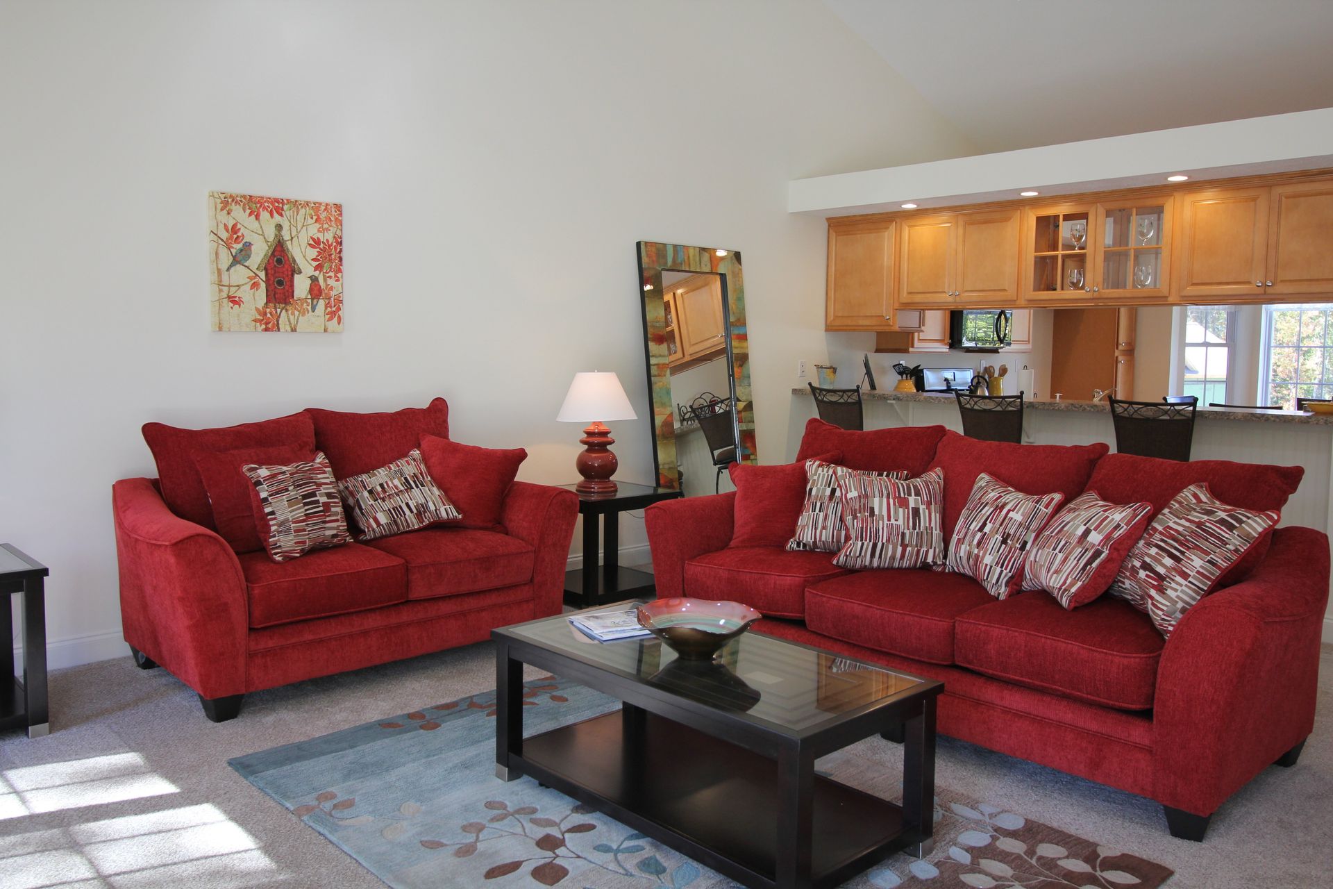 A living room with two red couches and a coffee table