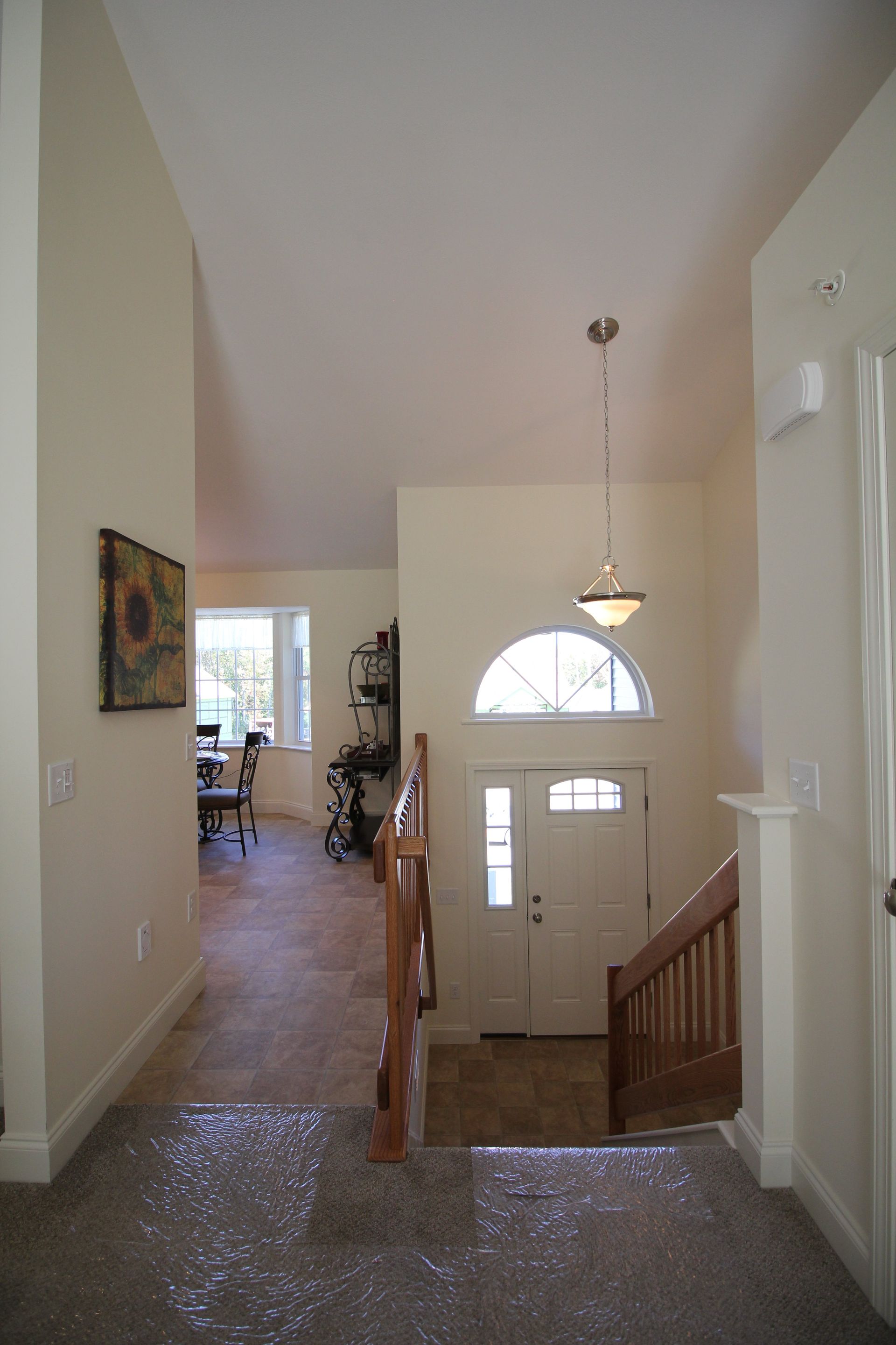 A hallway in a house with a staircase and a door