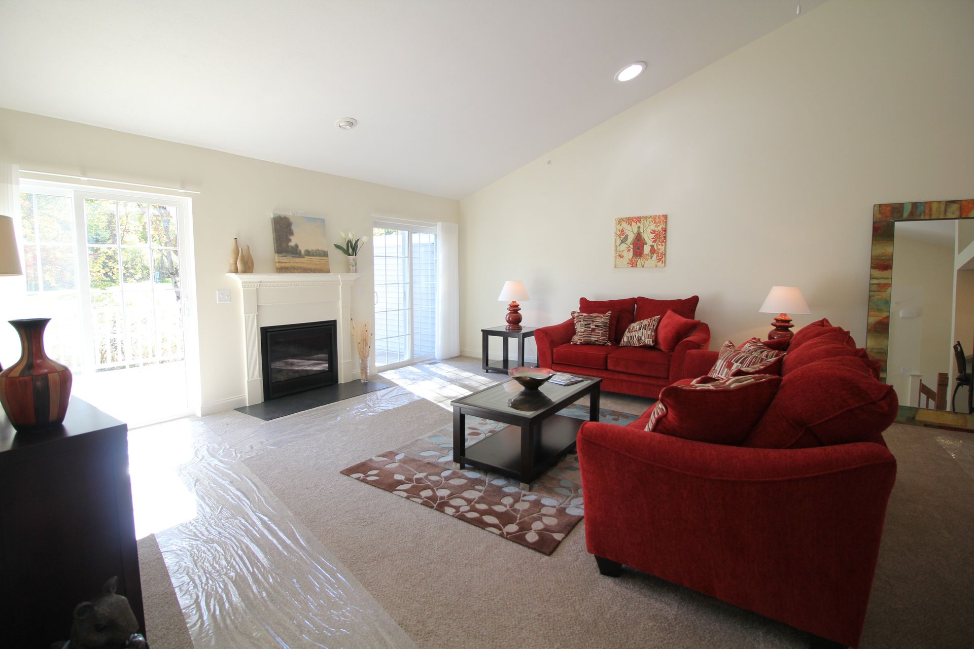 A living room with red furniture and a fireplace