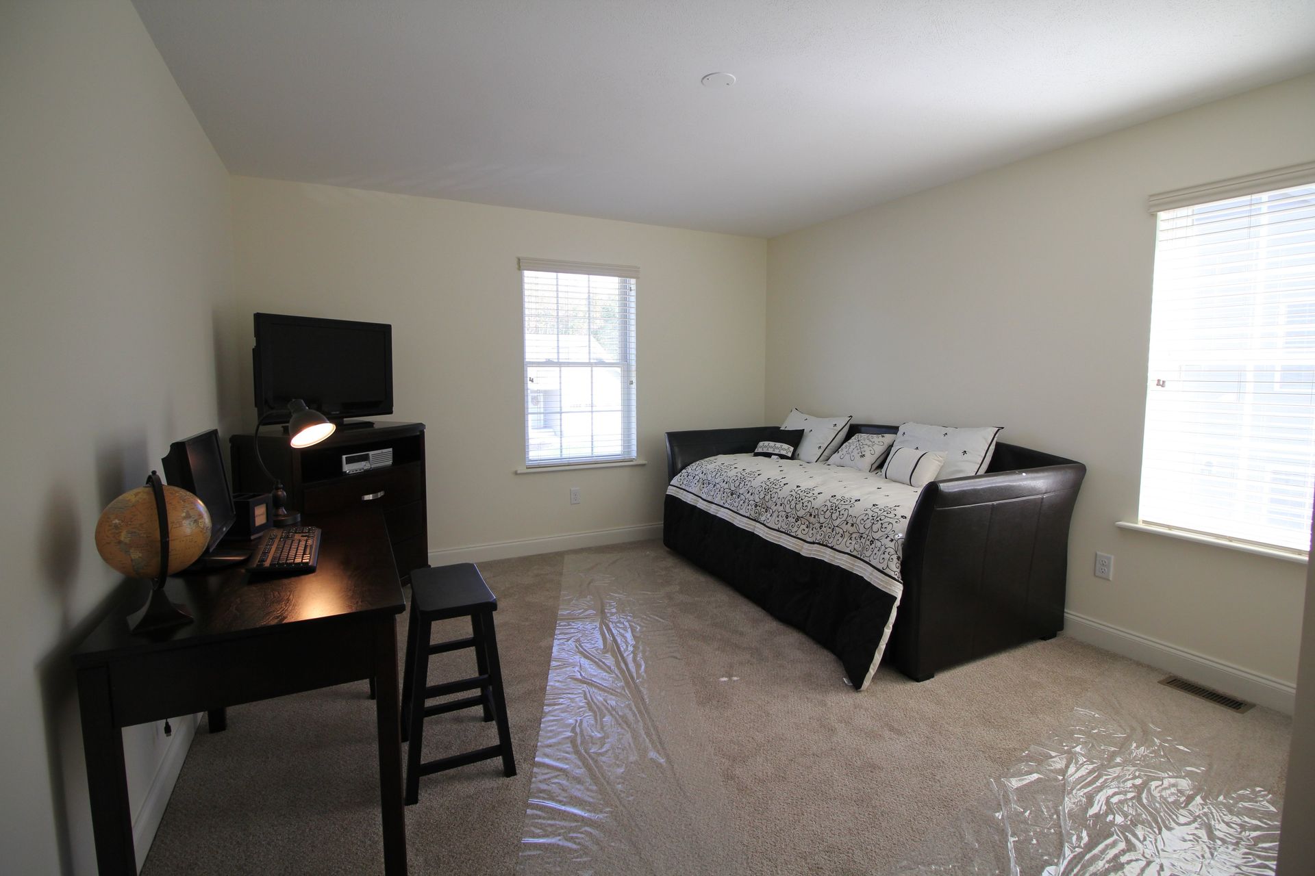 A living room with a couch , desk , and television.