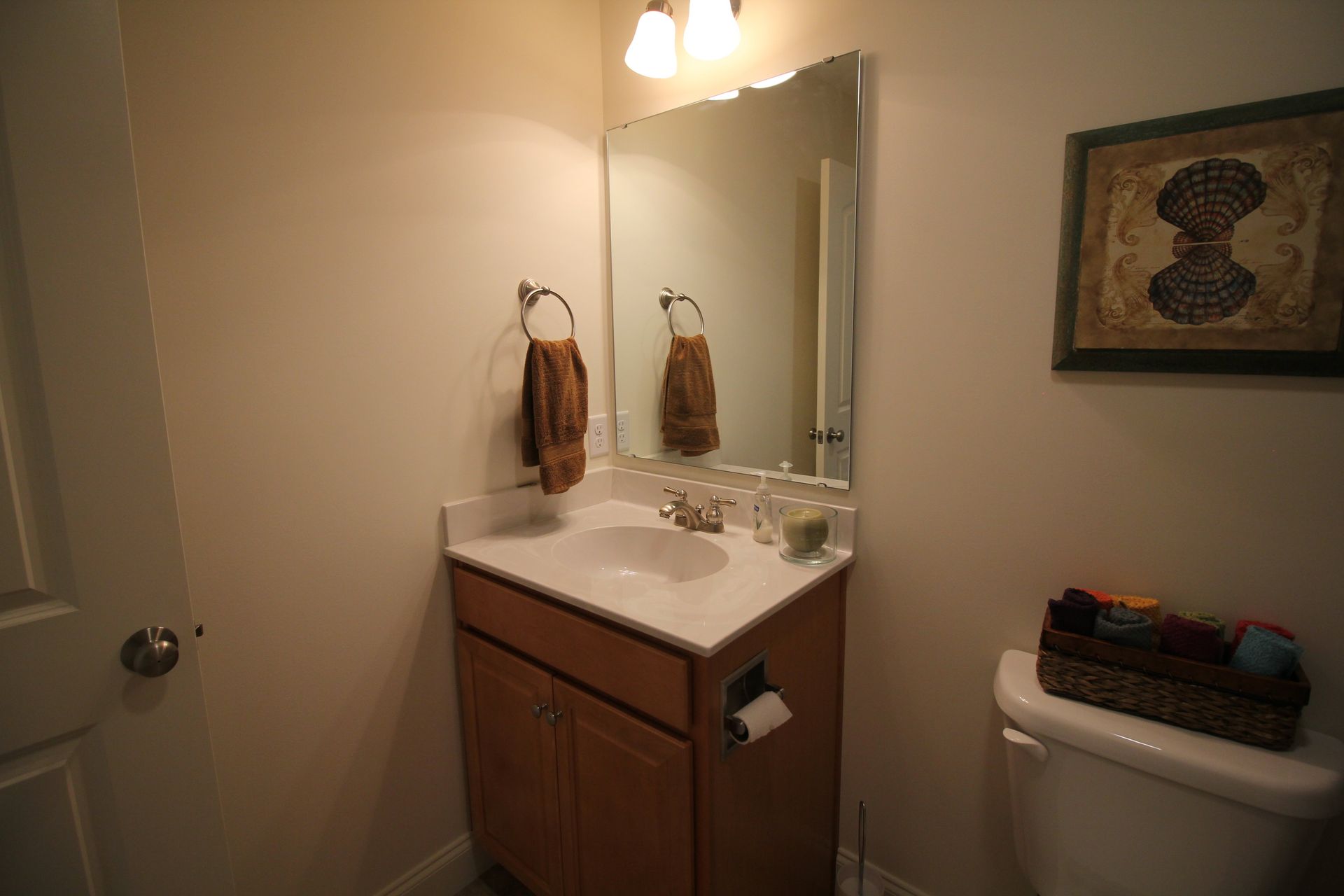 A bathroom with a sink , toilet and mirror.