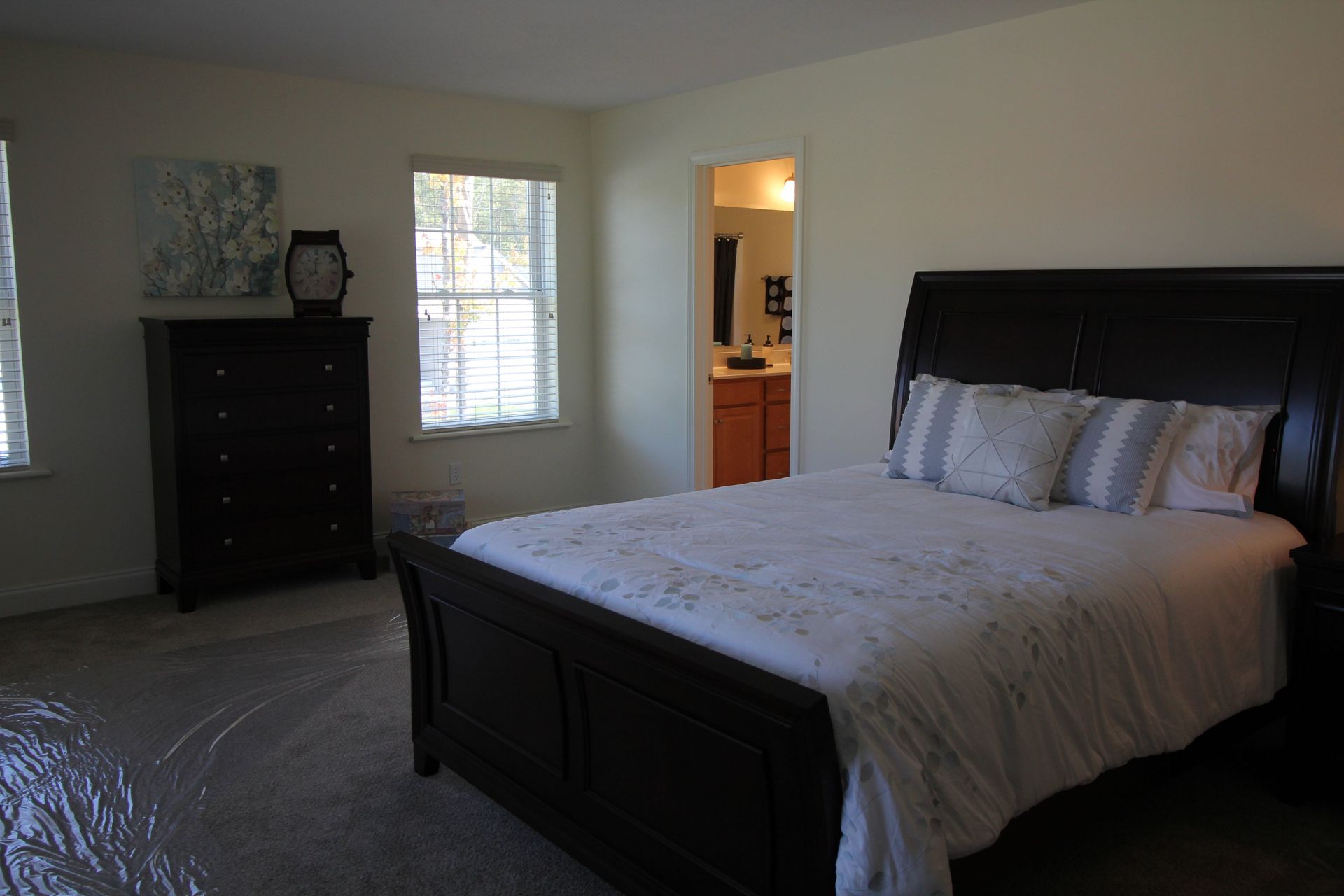 A bedroom with a large bed and a dresser