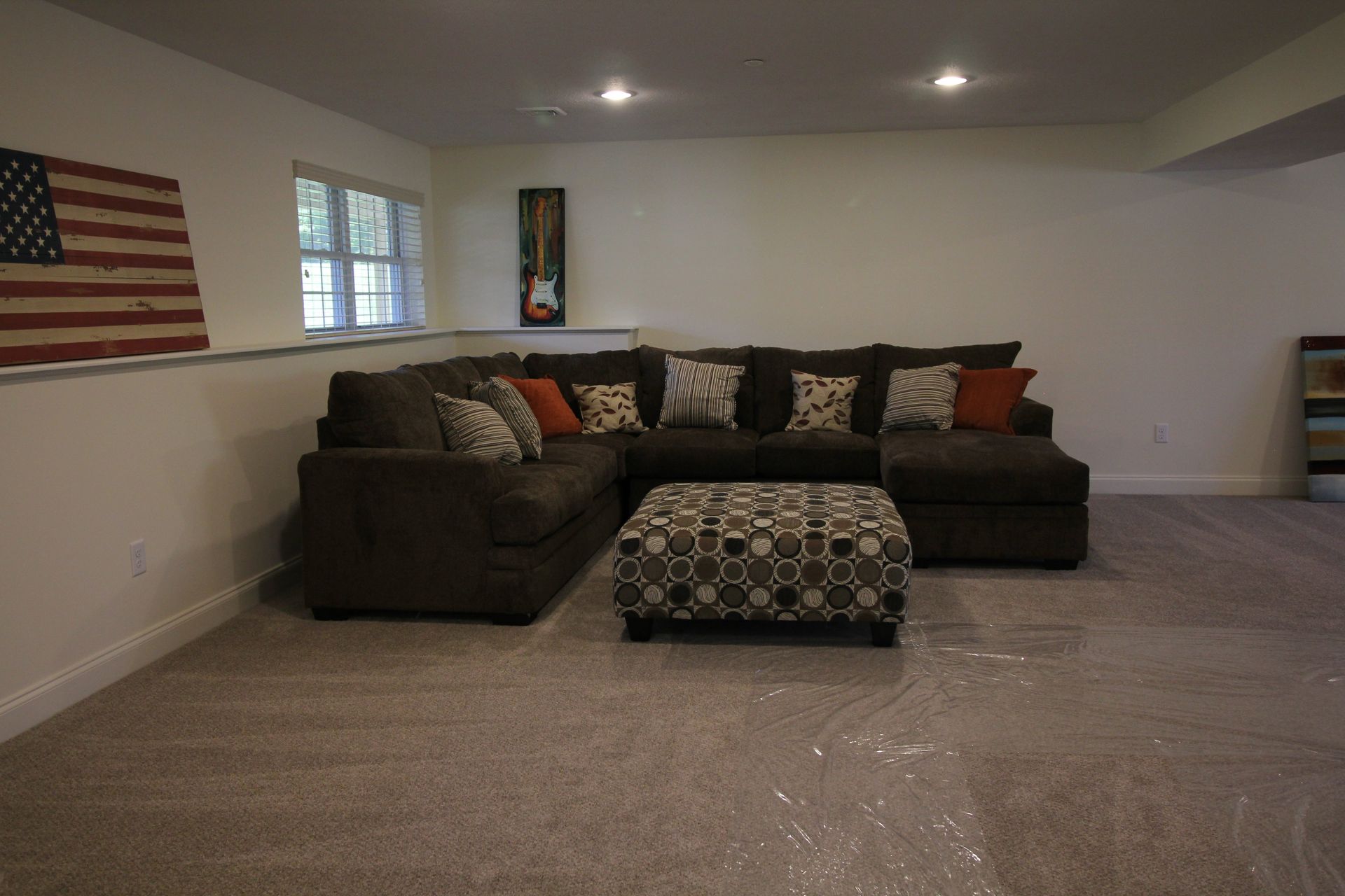 A living room with a large sectional couch and ottoman