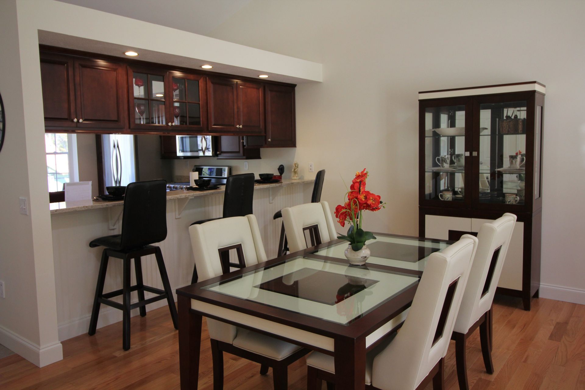 A dining room with a glass table and chairs