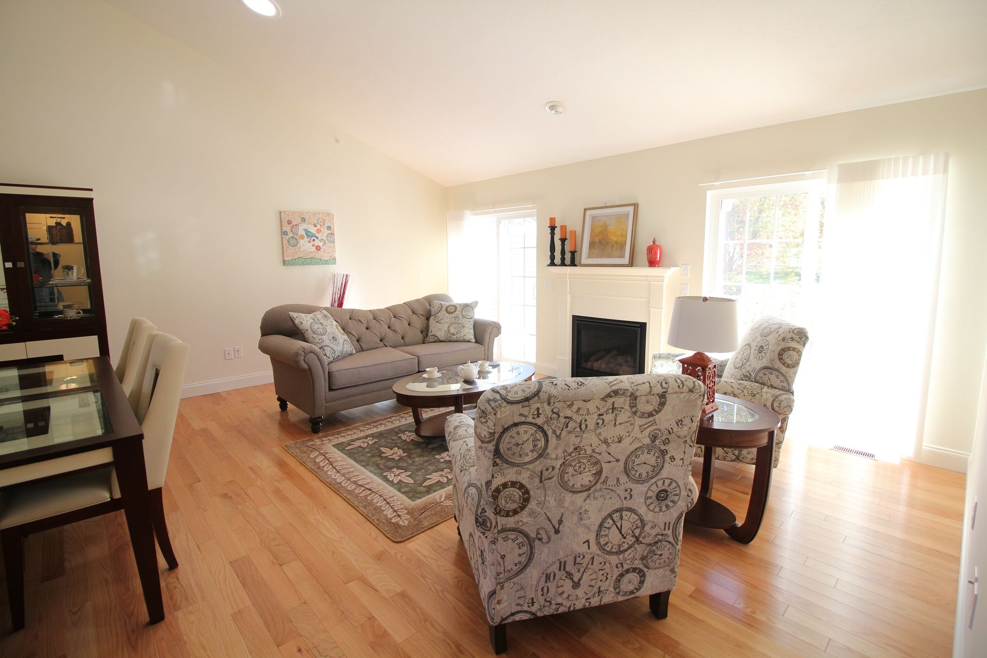 A living room with a couch , chairs , table and fireplace