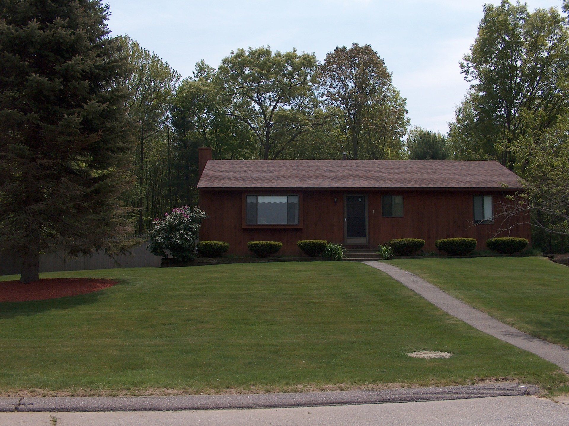 A house with a lush green lawn in front of it