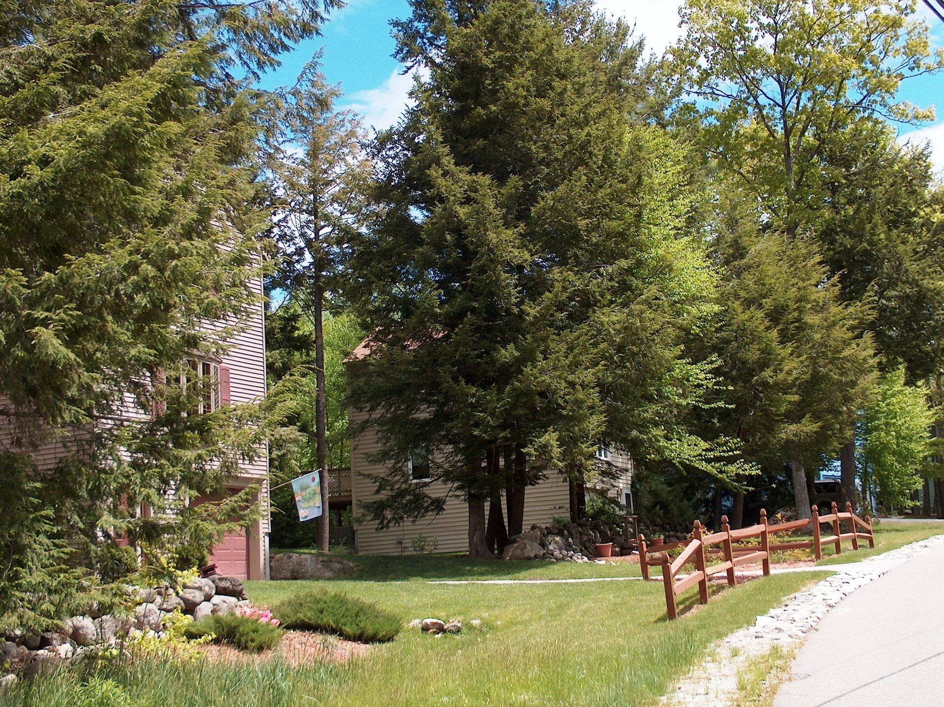 A house is surrounded by trees and a wooden fence.