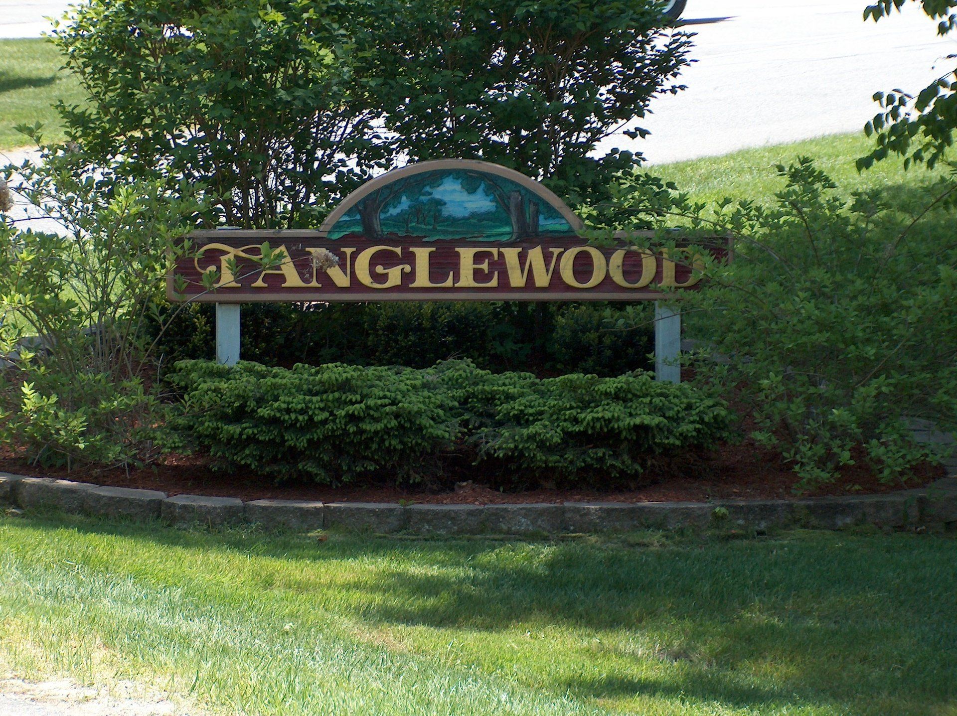 A sign that says tanglewood is in the grass