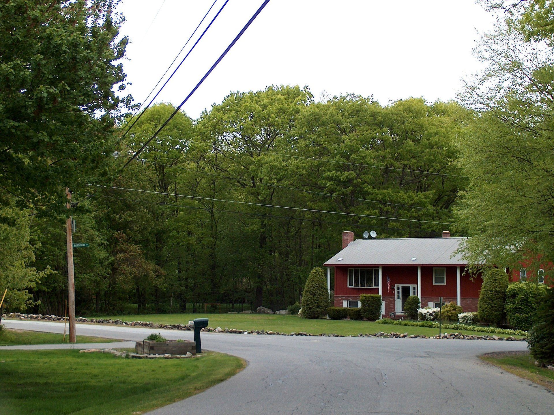 A red house sits on the corner of a street
