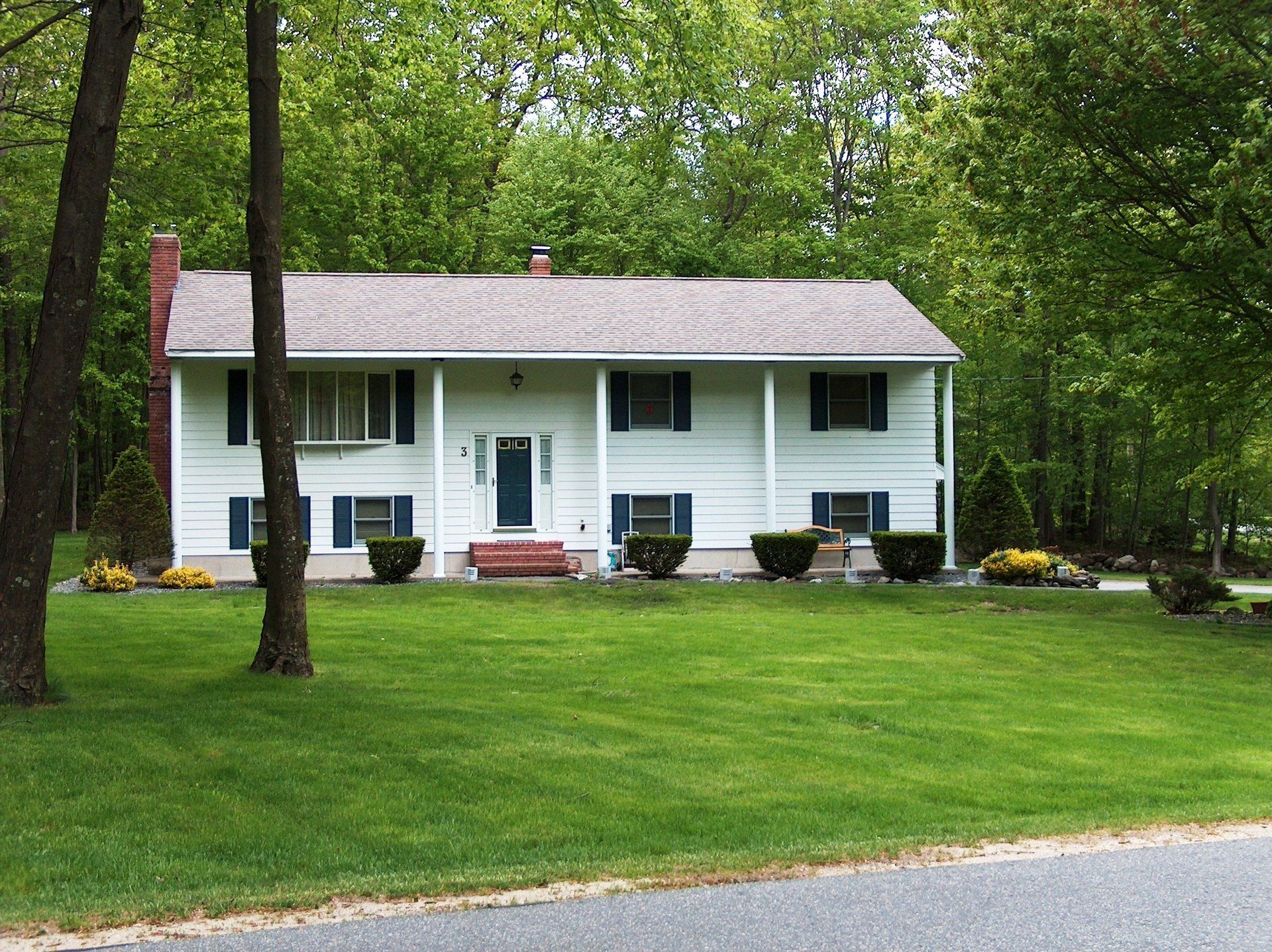 A white house with blue shutters and a porch