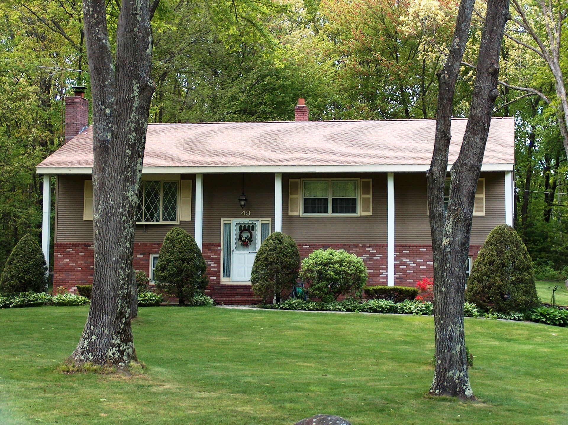 A house with a porch and a wreath on the door