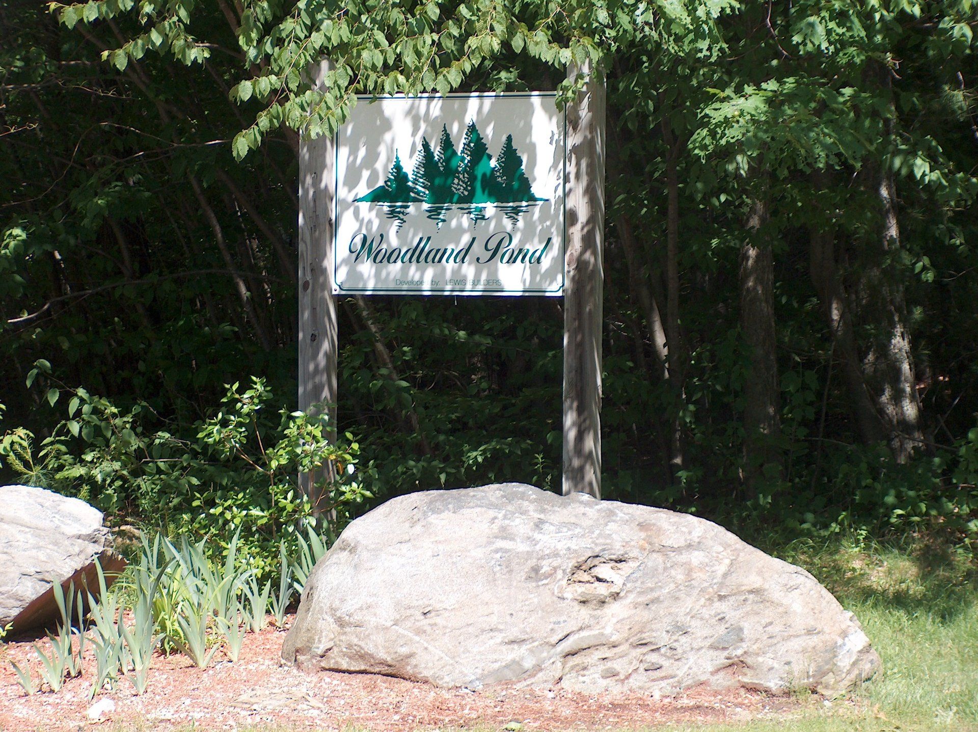 A large rock in front of a sign that says northwest road