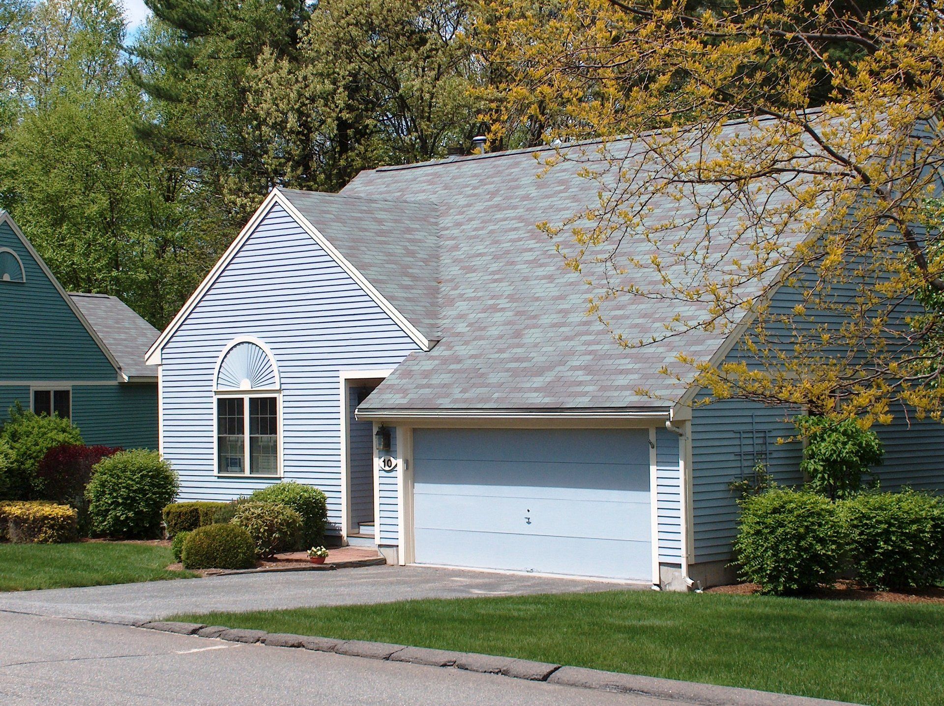 A house with a blue garage door and a gray roof