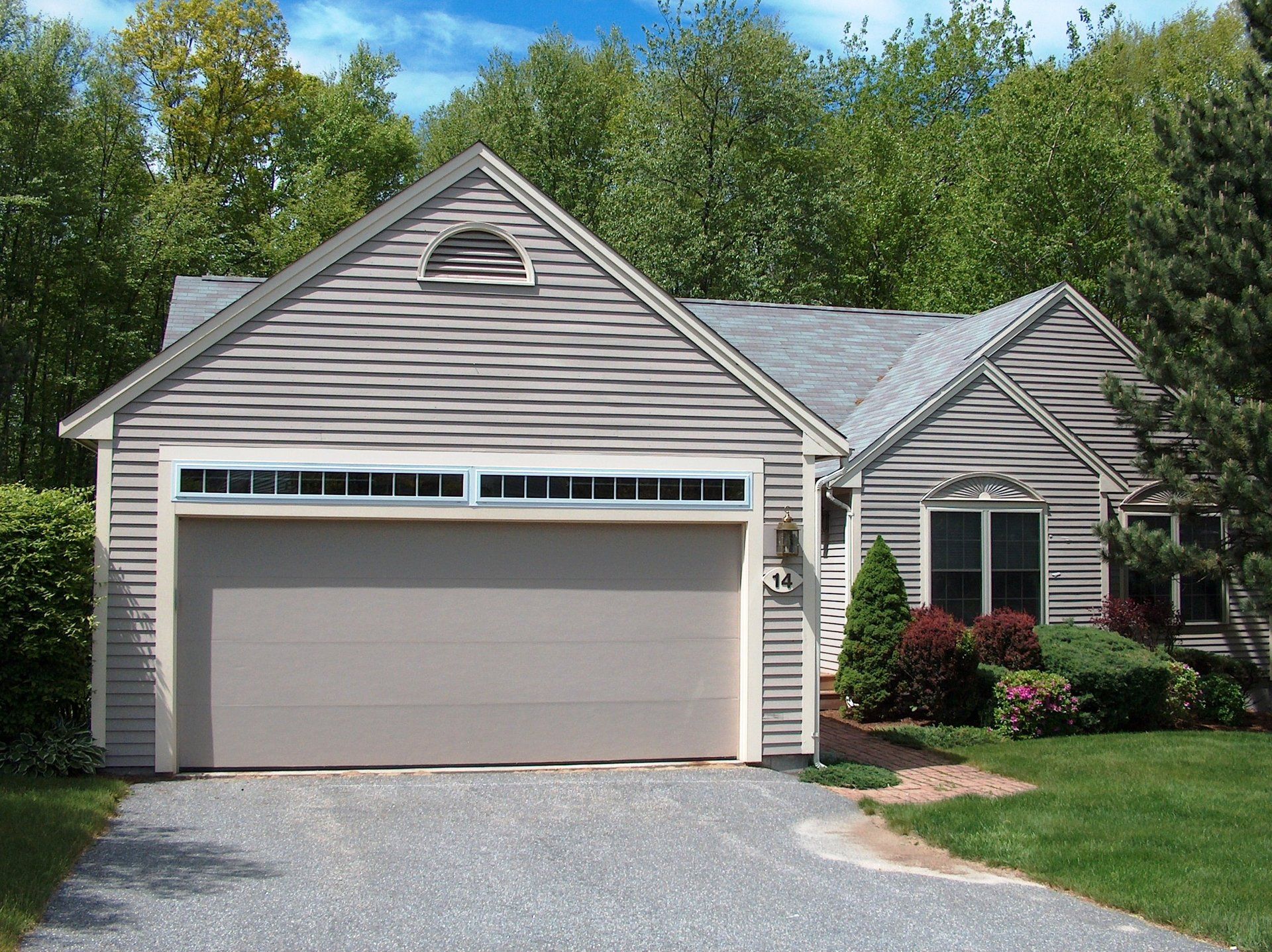 A house with a garage and a driveway in front of it