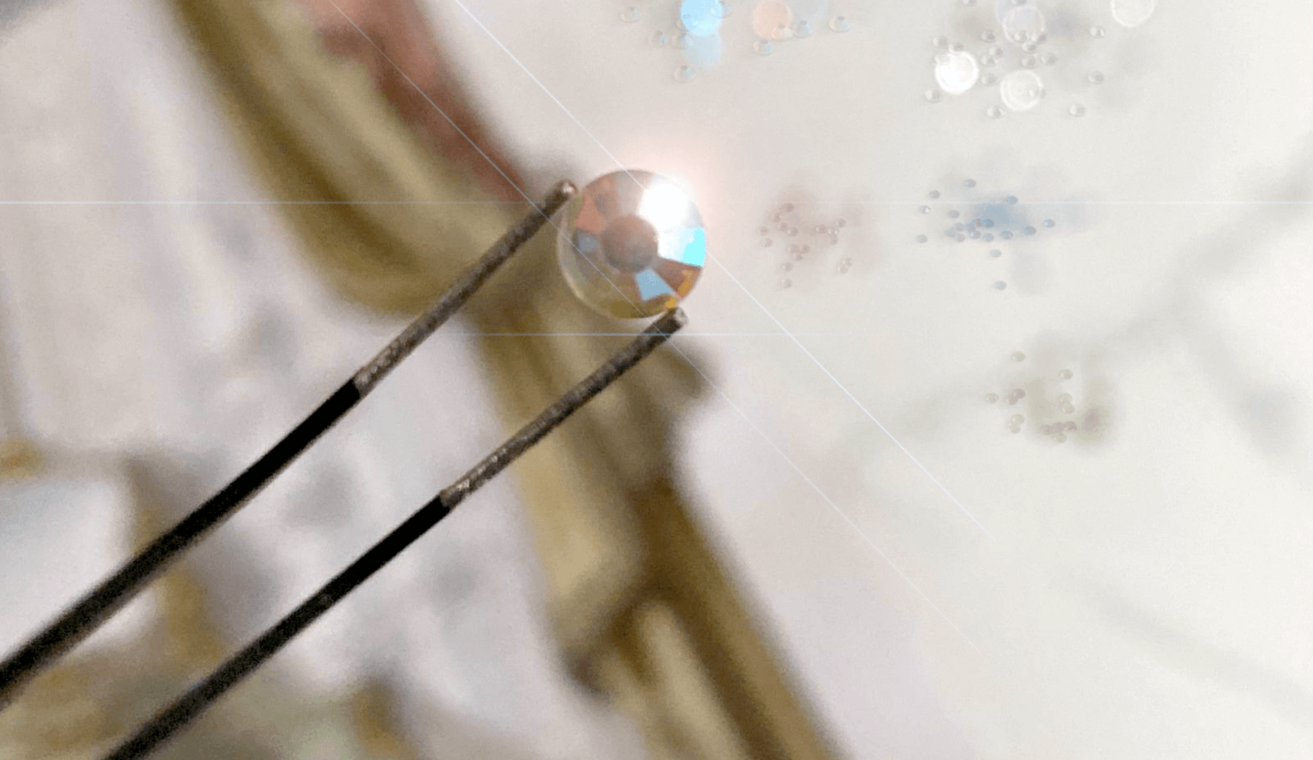 Een close-up van een pincet die een diamant vasthoudt.