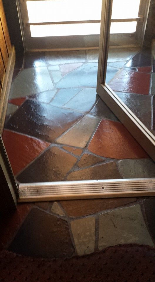 A doorway with a tiled floor and a mirror.
