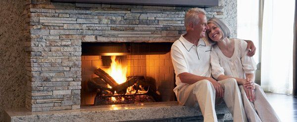 man and woman sitting by fireplace