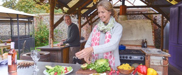 people cooking in outdoor kitchen space