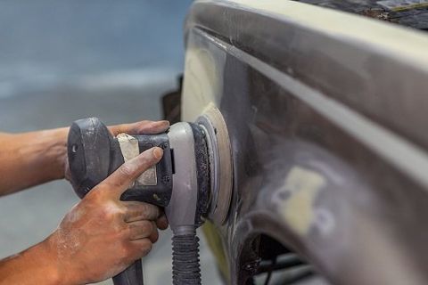 Fiberglass—Grinder in the hands of a man who sharpen a car varnish in the car shop in Delran, NJ Fiberglass—Grinder in the hands of a man who sharpen a car varnish in the car shop in Delran, NJ