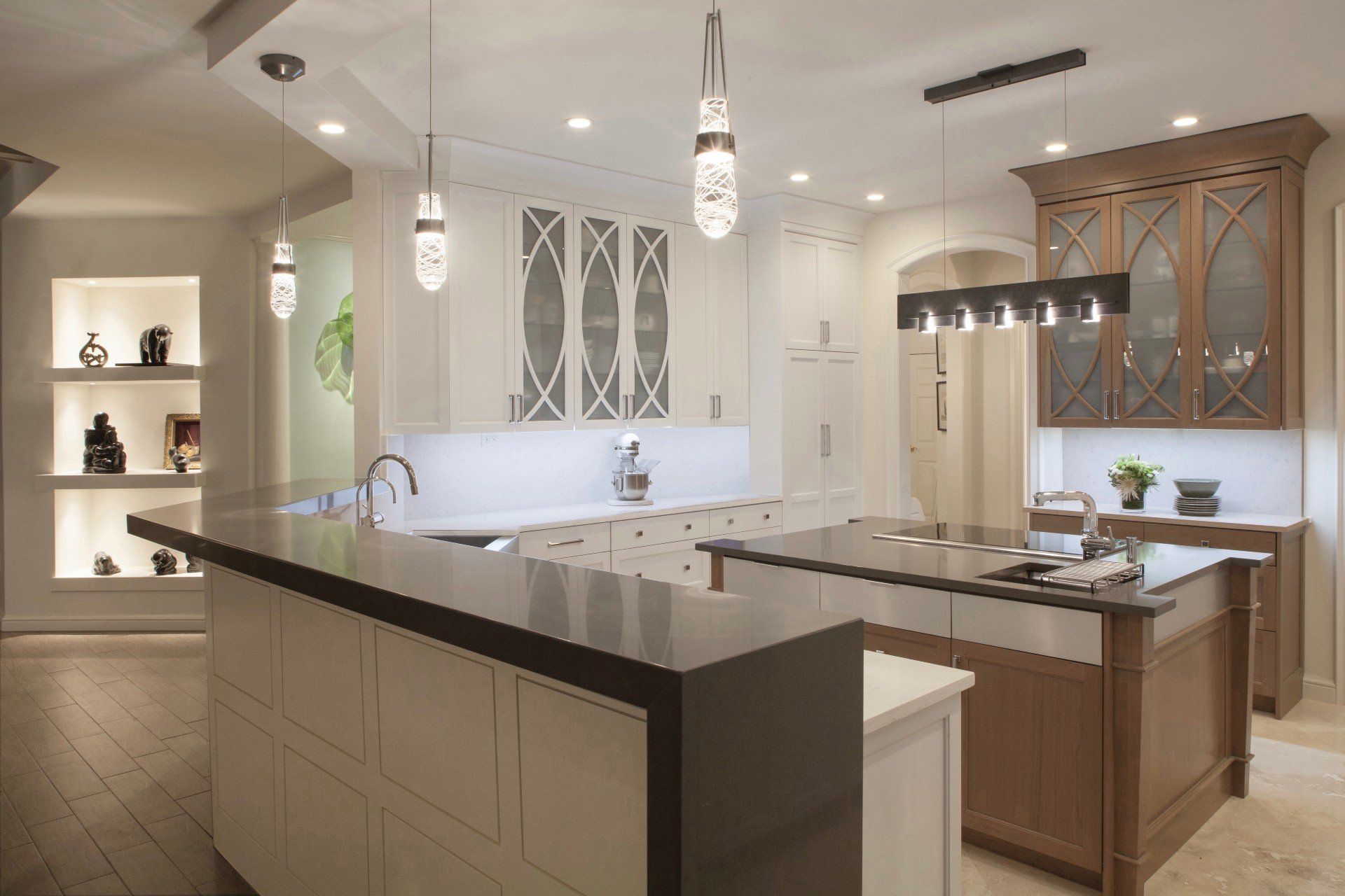 Bright modern kitchen with white cabinets, dark countertops, and pendant lights.