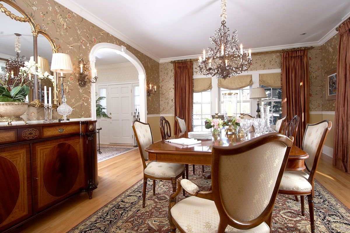 Elegant dining room with chandelier, wooden table, cream chairs, and ornate decor