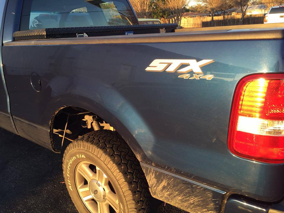a blue stx 4x4 truck is parked in a parking lot