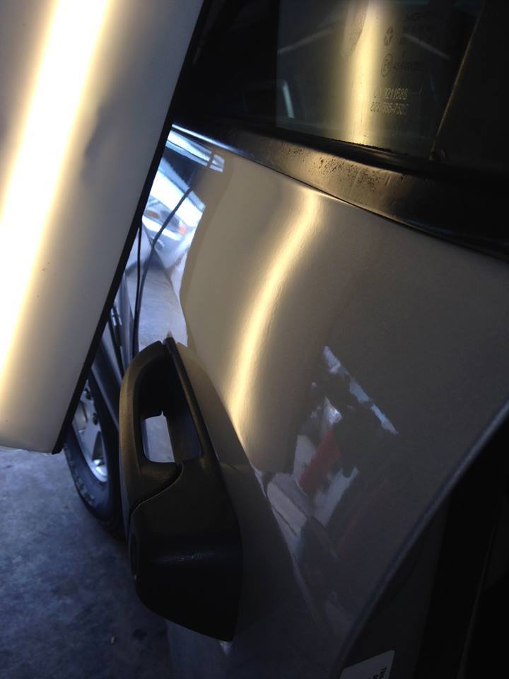 a close up of a car door with a dent in it