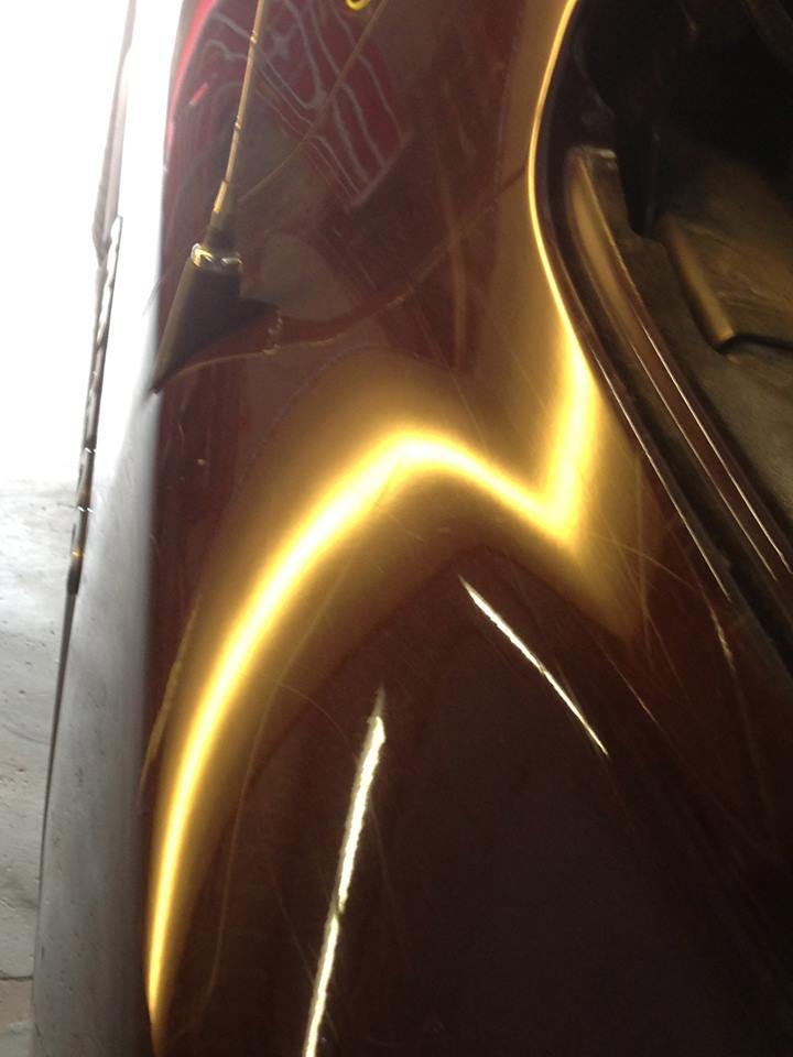 a close up of a brown car with a yellow stripe on the side