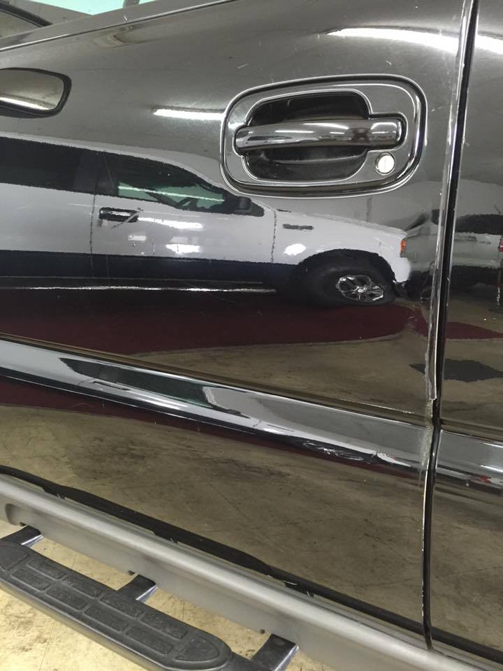 a black car with chrome handles is parked in a garage