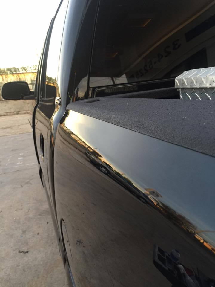 a black truck is parked in a parking lot