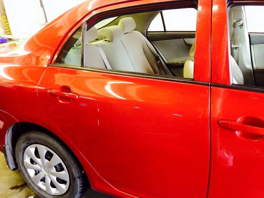 a red car is parked in a garage with the door open