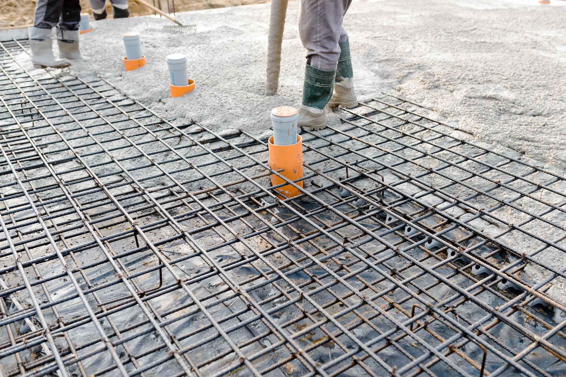 A man is pouring concrete into a concrete slab on a construction site  — Building Services in Rockhampton