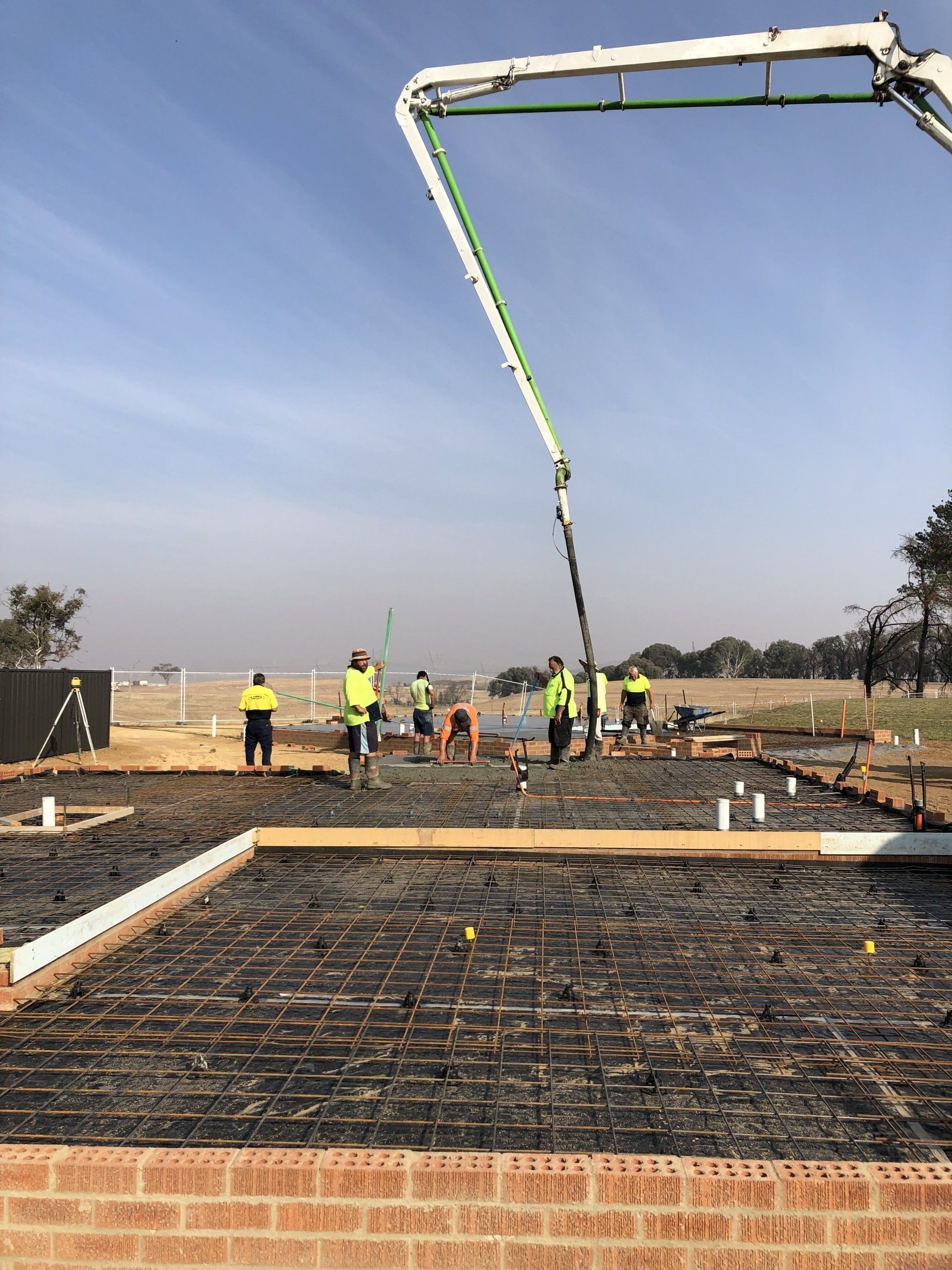 A group of construction workers are working on a concrete floor.