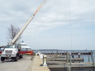 Worker in bucket truck trimming tree — crane service in Muskegon & Ottawa Counties MI Worker in bucket truck trimming tree — crane service in Muskegon & Ottawa Counties MI