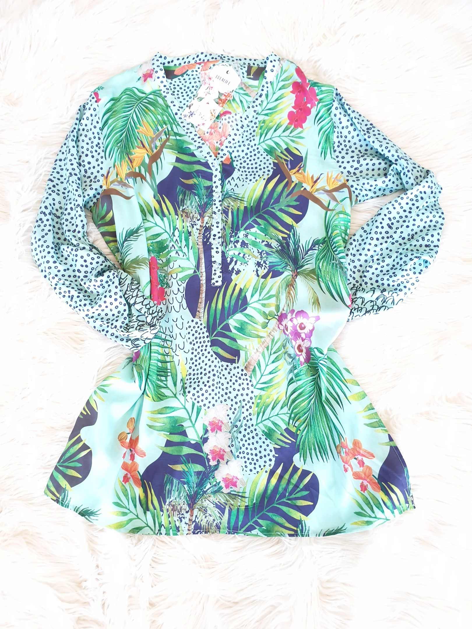Tropical print long-sleeved blouse with green, pink, and blue hues.