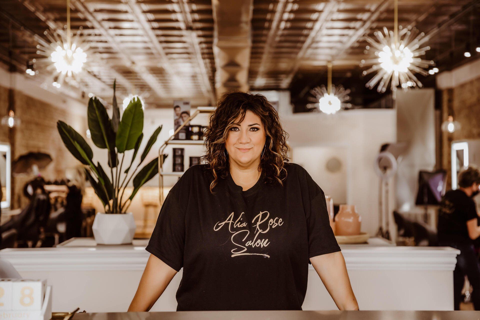 Woman in a salon wearing a black shirt with 