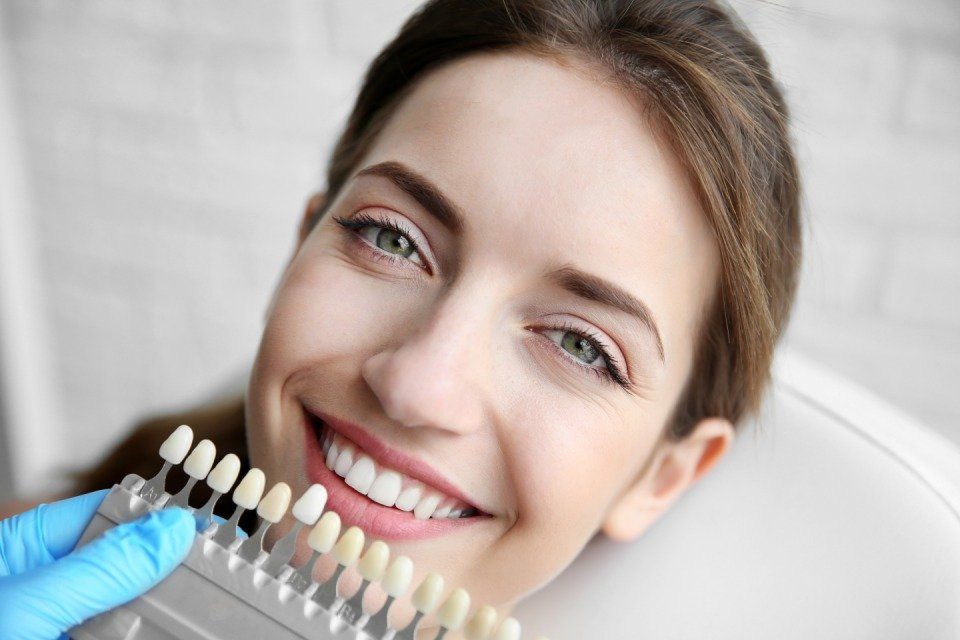 doctor checking woman teeth color