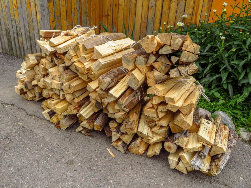 A pile of wood is sitting on the side of the road.